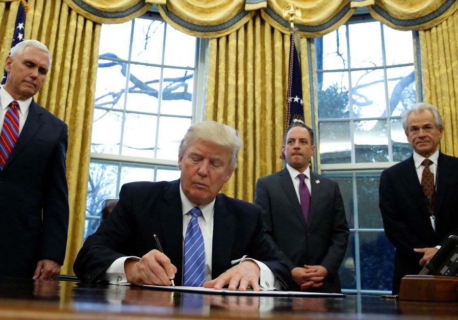 US President Donald Trump signs an executive order in the Oval Office of the White House