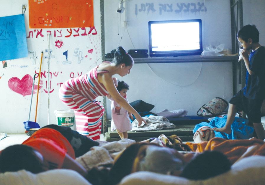 A MOTHER puts her children to bed in a public bomb shelter in Ashkelon during the 2014 Gazan war