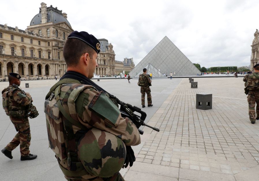 French army soldiers patrol near the Louvre Museum Pyramid's main entrance in Paris, France
