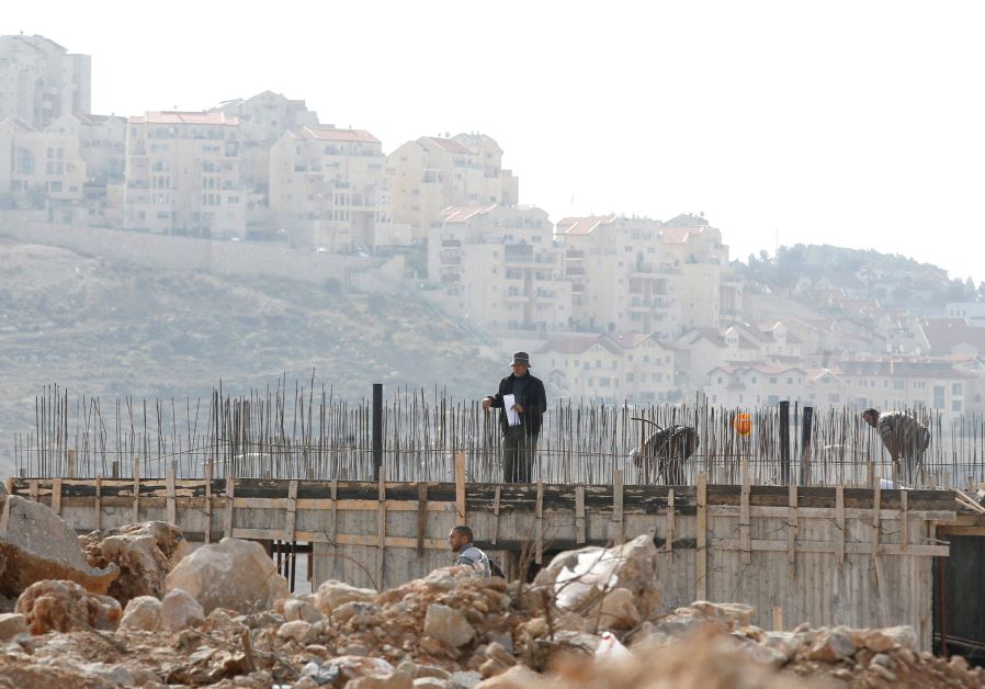 Palestinian labourers work at a construction site in Efrat