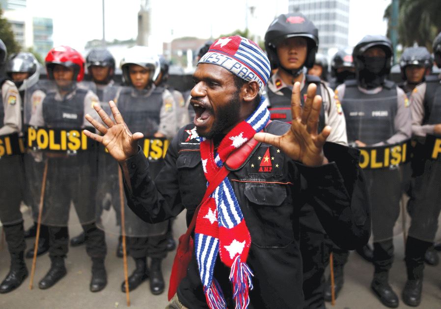 An activist shouts near a police line during a rally to commemorate the West Papuan declaration of independence