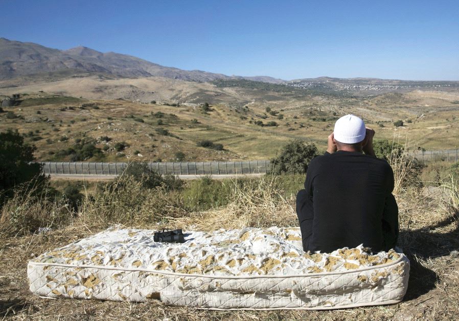 A DRUSE man watches the fighting in Syria from the Israeli side of the Golan Heights