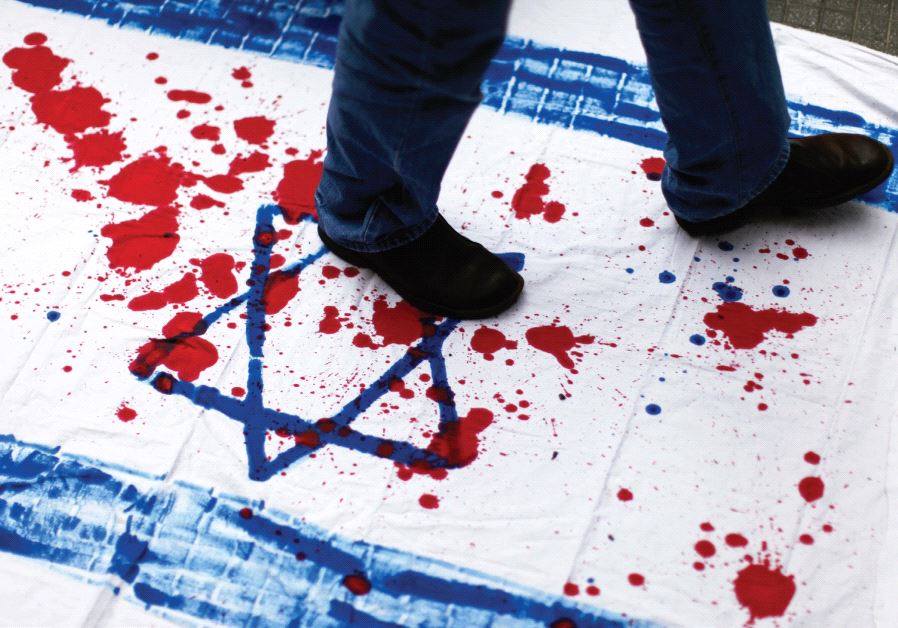 A VENEZUELAN student walks over a cloth with red paint and the Star of David during an anti-Israel demonstration.
