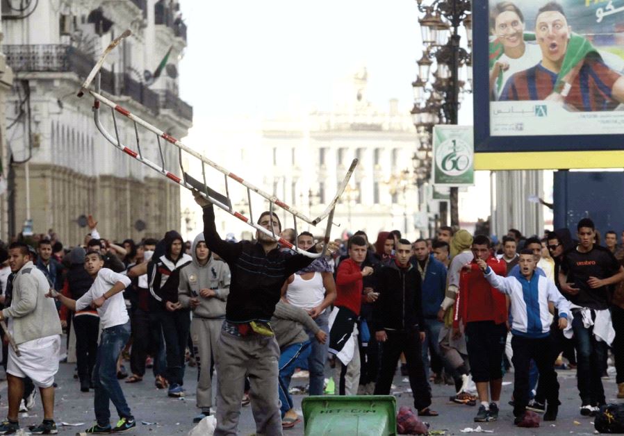 Demonstrators confront police during clashes after Friday prayers in Algiers, January 16