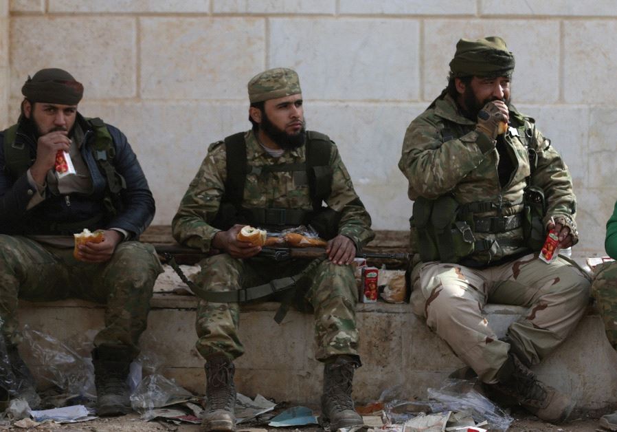SYRIAN REBEL fighters take a rest during battles around al-Bab in northern Syria