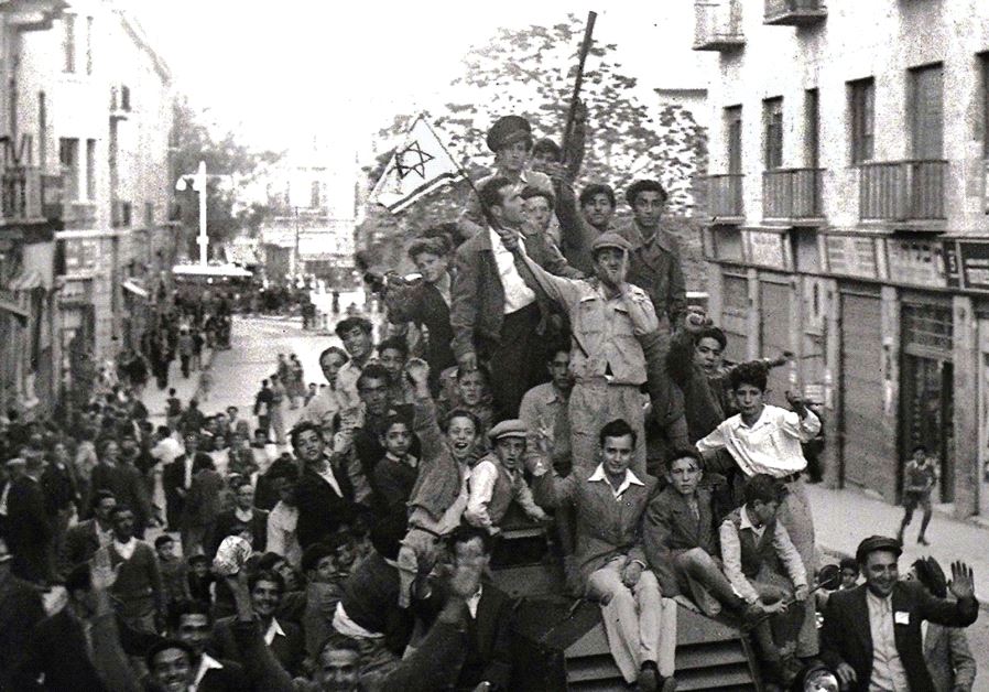 JEWS CROWD onto a British army armored car as they celebrate in downtown Jerusalem the morning after the United Nations voted to partition British mandate Palestine into a Jewish and an Arab state.