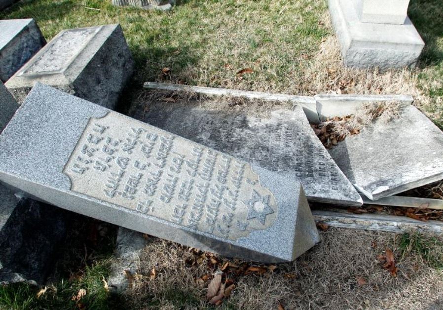 A headstone, pushed off its base by vandals, lays on the ground near a smashed tomb in the Mount Carmel Cemetery, a Jewish cemetery, in Philadelphia, Pennsylvania, U.S. February 27, 2017
