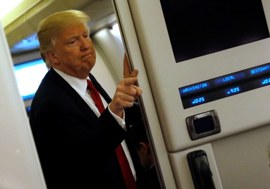 US President Donald Trump speaks to reporters aboard Air Force One