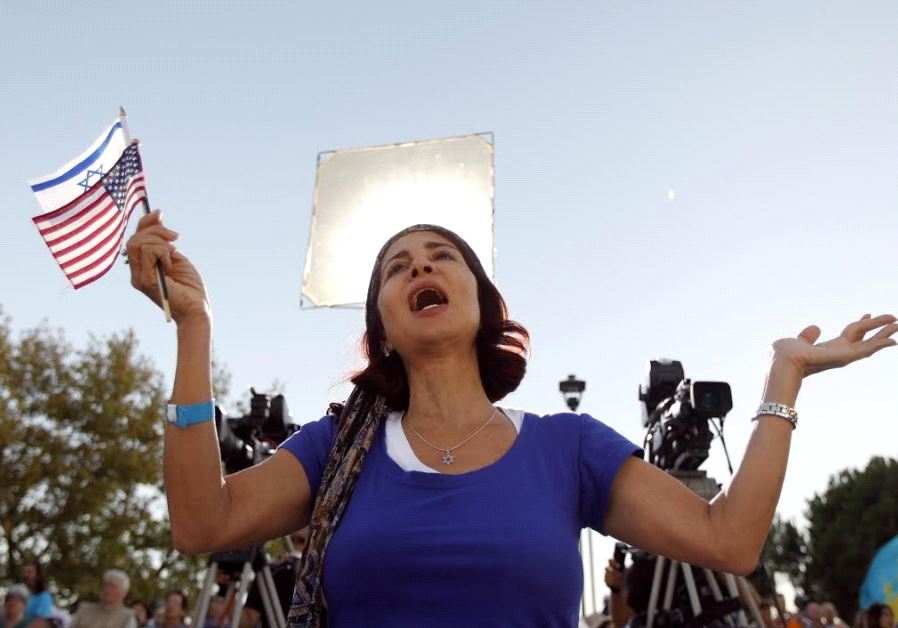 A worshiper, holding an American and an Israeli flag, prays during The Day of Prayer for the Peace of Jerusalem, on Jerusalem’s promenade, in 2011.