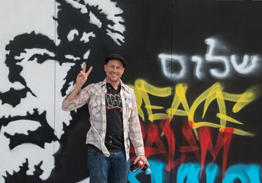 Graffiti artist and actor Corin Nemec stands by his creation at the Peres Center for Peace.