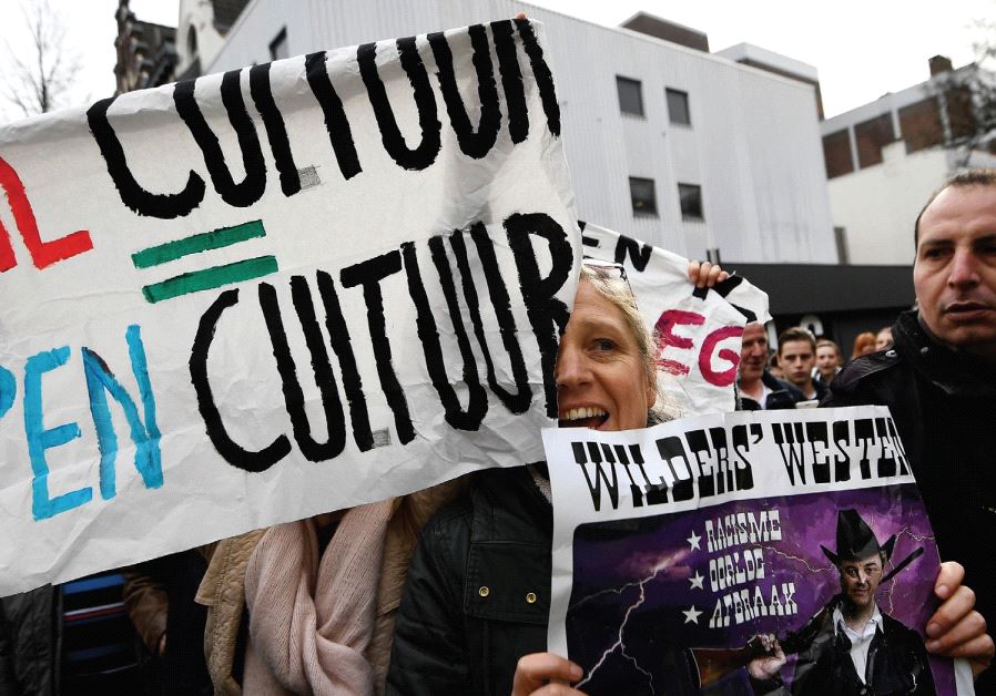 PRO-IMMIGRATION ACTIVISTS shout as they are stopped by police during a visit by Dutch far-right politician Geert Wilders of the PVV party in Heerlan, Netherlands in March 2017.