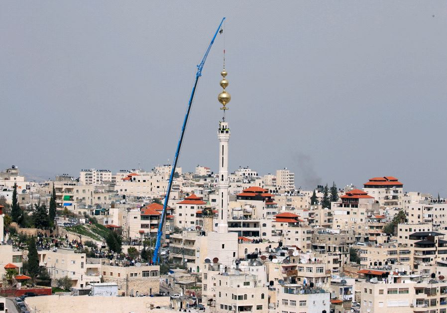 Palestinian workers prepare golden crescent to set it on top of a mosque's minaret in the East Jerusalem neighbourhood of Issawiya March 17, 2017. 