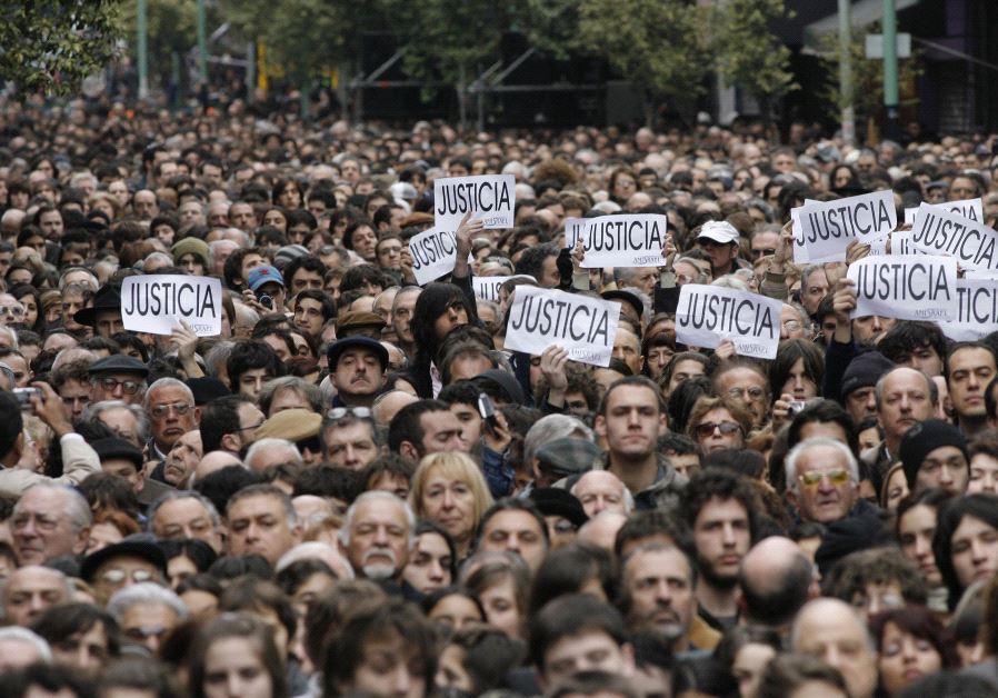 Hundreds of people, most of them members of the Argentine Jewish community, attend the commemoration of the 13th anniversary of the 1994 bombing of the AMIA Jewish community center in Buenos Aires July 18, 2007. The signs read, "Justice.