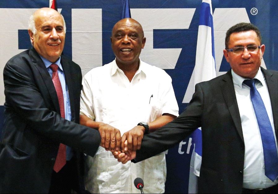 Jibril Rajoub (left), president of the Palestinian Football Association, Tokyo Sexwale (center), chairman of the FIFA Monitoring Committee Israel-Palestine and Israel Football Association president Ofer Eini shake hands following a news conference in Jericho in December 2015.
