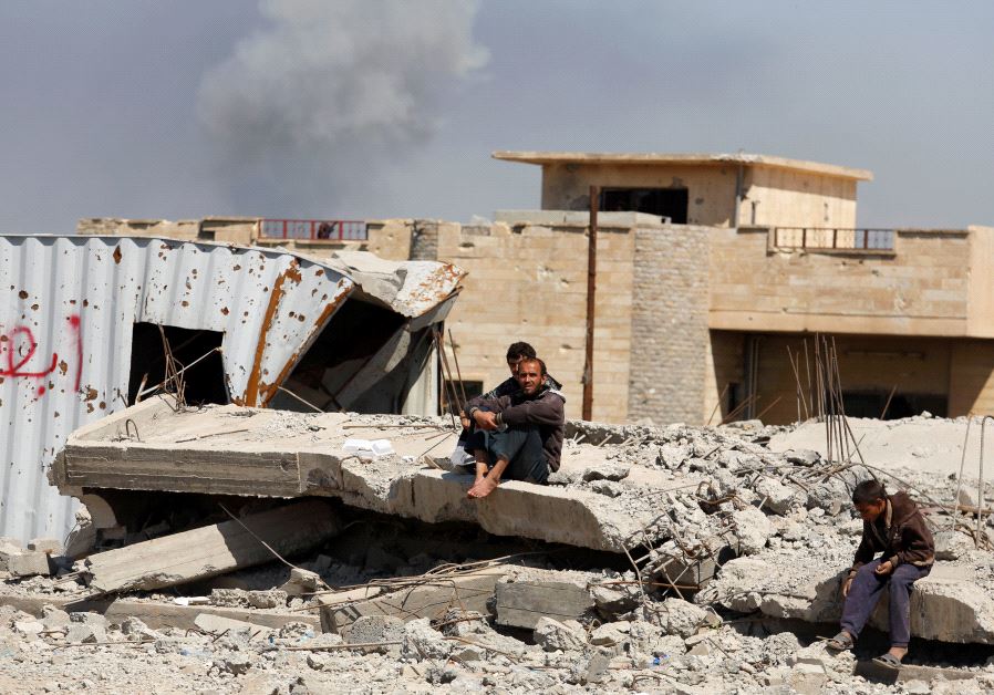 Smoke rises while displaced Iraqis wait to get food supplies as Iraqi forces battle with Islamic State militants, in western Mosul, Iraq March 27, 2017