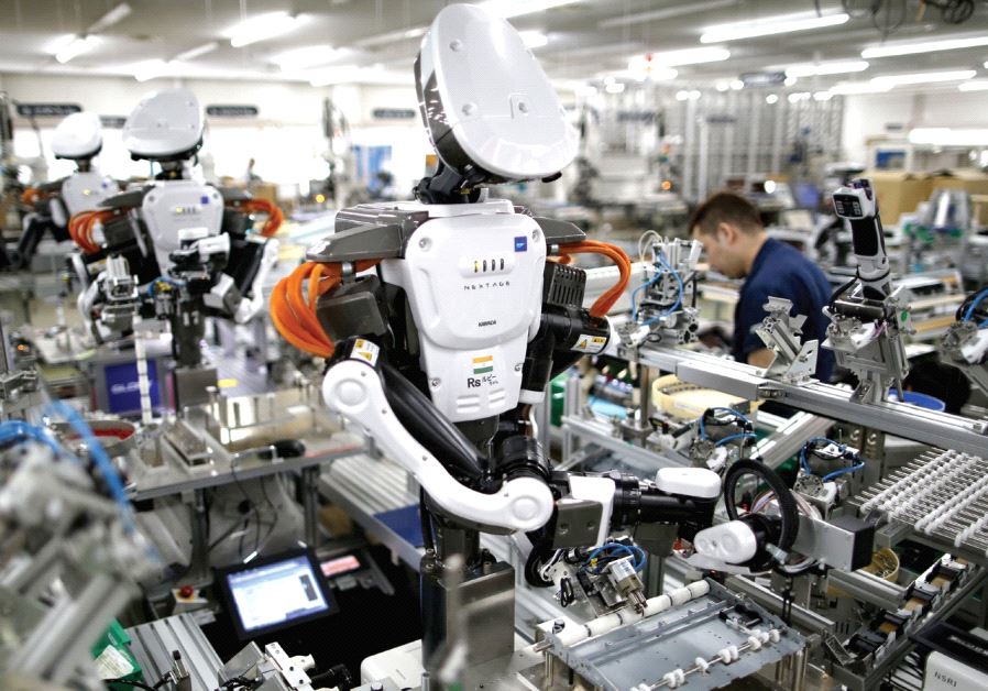 Humanoid robots work side by side with employees in the assembly line at a factory near Tokyo, Japan
