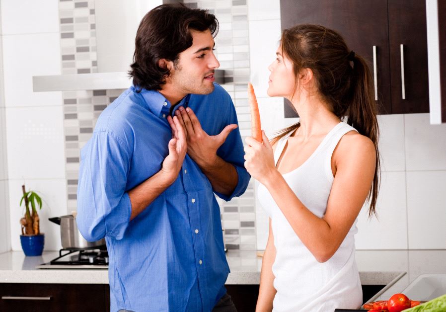 Young couple argue in the kitchen (illustrative)