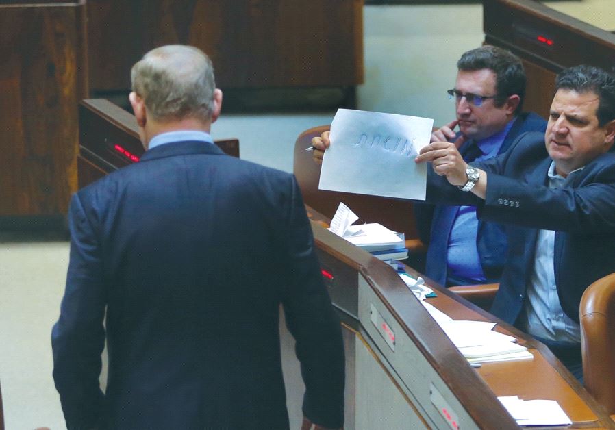 JOINT LIST chairman Ayman Odeh holds a piece of paper with the word ‘corrupt’ on it toward Prime Minister Benjamin Netanyahu in the Knesset