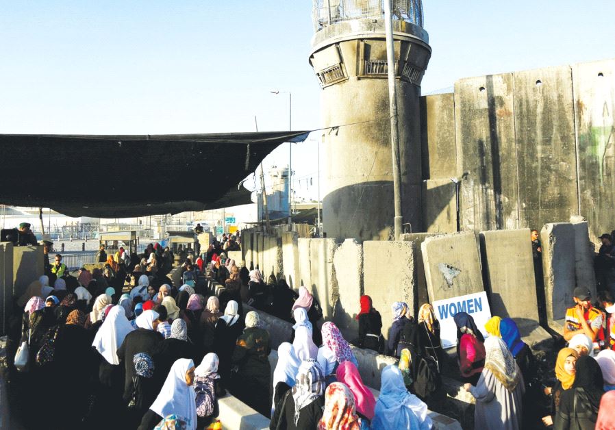 Palestinians wait to cross through Kalandiya checkpoint into Israel, near Ramallah.