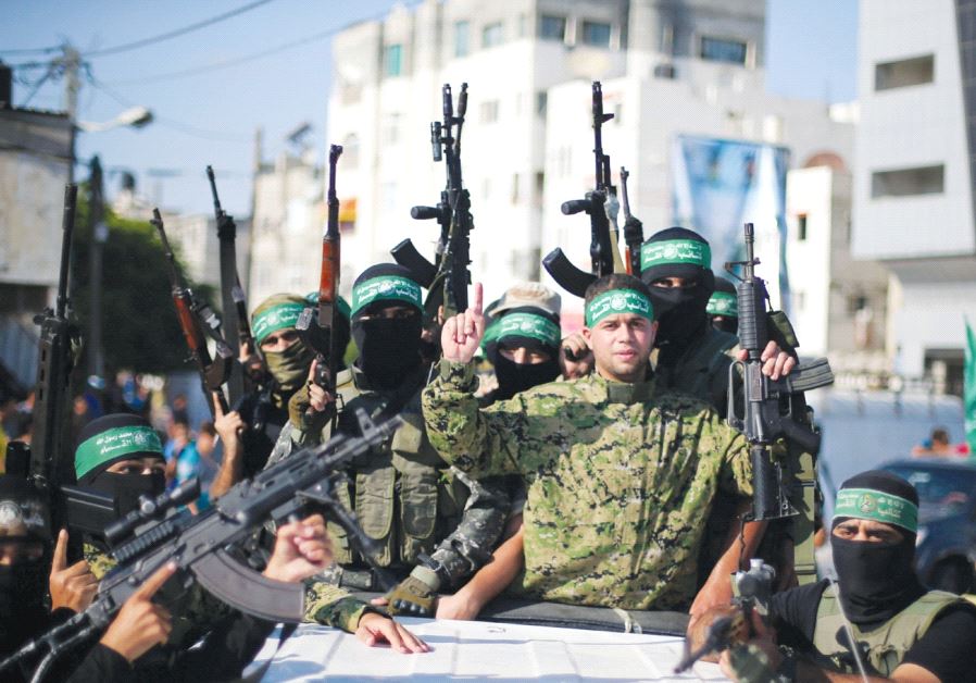 Freed Palestinian prisoner Mohammed al-Bashiti, who served 12 years in an Israeli jail after he was convicted of being a member of Hamas’s armed wing, gestures as he holds a weapon in a pickup truck with Hamas militants upon his release, in the southern Gaza Strip, last year