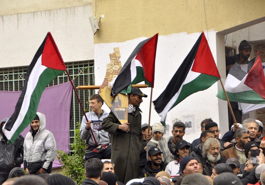 Palestinian residents of the Yarmouk refugee camp in the Damascus district of Syria wave their national flags as they take part in a protest expressing their will to stay inside the camp.