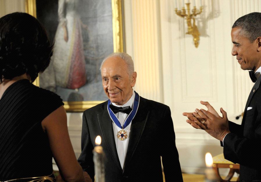 PRESIDENT BARACK OBAMA and first lady Michelle Obama applaud after awarding Peres the Presidential Medal of Freedom at the White House in 2012.