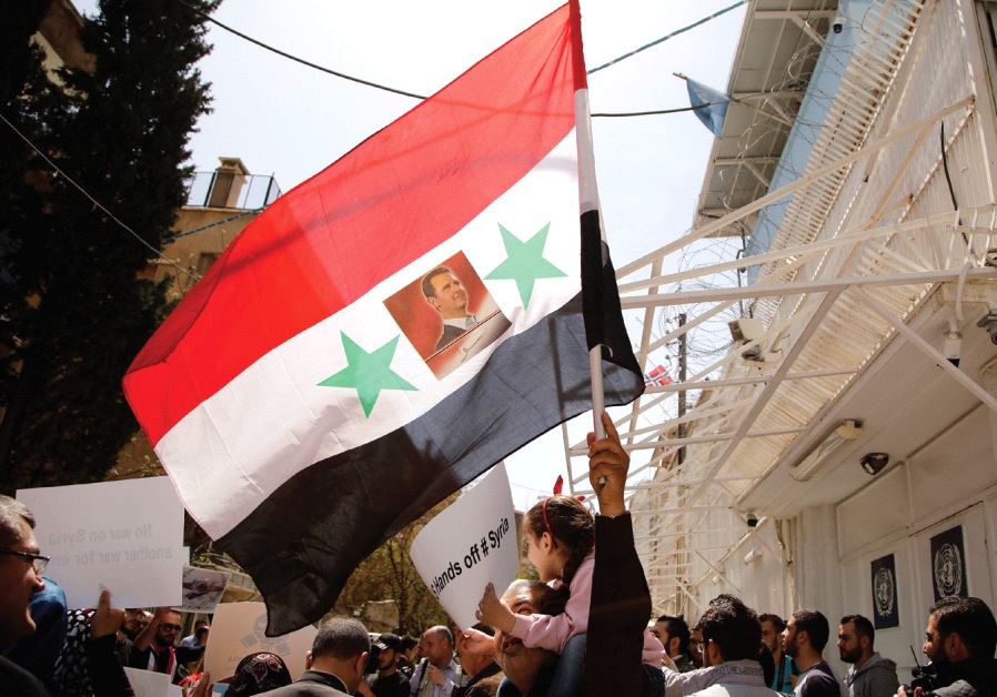PEOPLE ATTEND a protest against American airstrikes in Syria, in front of a United Nations building in Damascus.