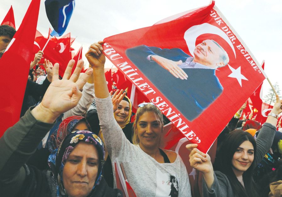 SUPPORTERS OF Turkish President Tayyip Erdogan wave national flags as they wait for his arrival at the Presidential Palace in Ankara.