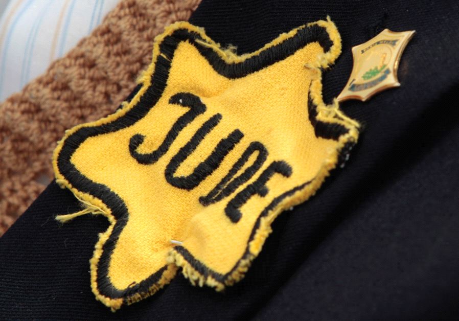 a holocaust survivor wears a yellow Star of David on his jacket during a ceremony marking Holocaust Remembrance Day at Yad Vashem Holocaust Memorial in Jerusalem