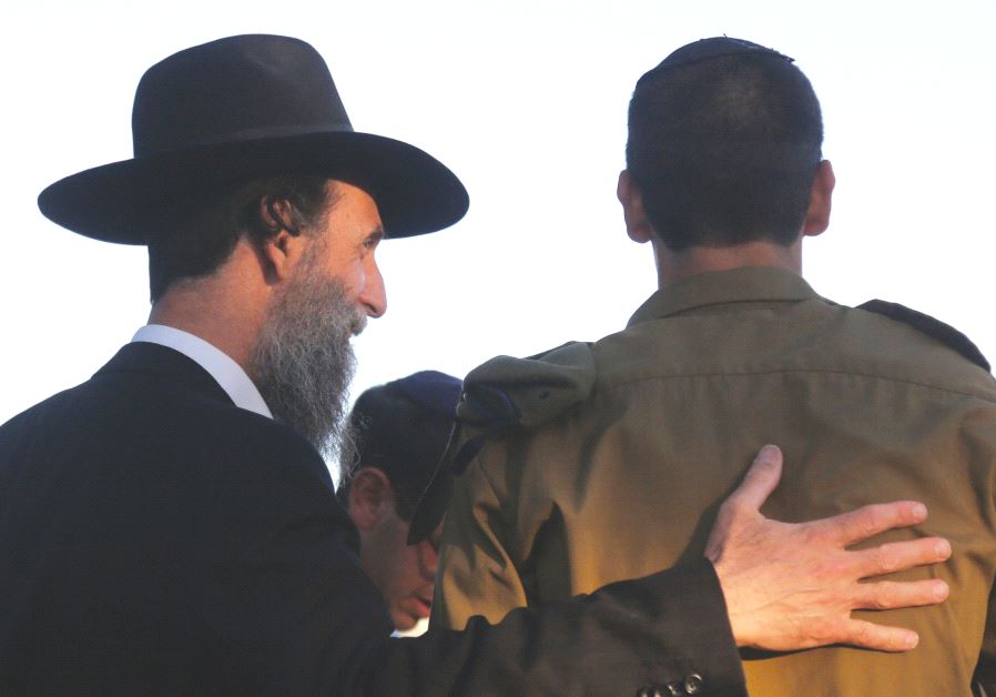 A haredi man embraces a youth from the Orthodox community who has joined the army