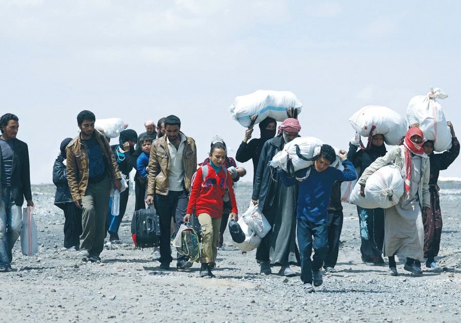 PEOPLE WHO FLED Raqqa city carry their belongings as they leave a camp in Ain Issa, in Syria’s Raqqa governorate, on Thursday.