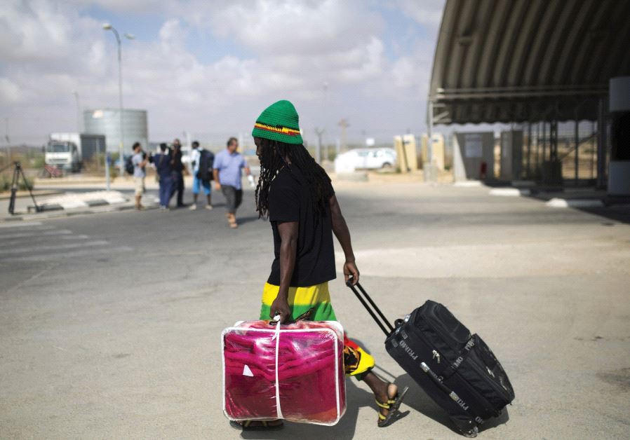 AN AFRICAN migrant walks with his luggage after being released from Holot detention center in the Negev in 2015.