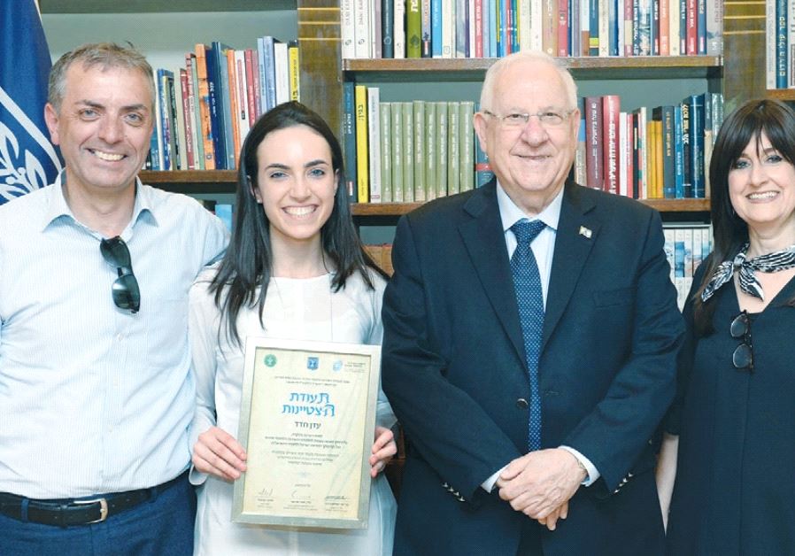 PRESIDENT REUVEN RIVLIN smiles alongside outstanding Civilian National Service volunteers at his official residence in the capital yesterday