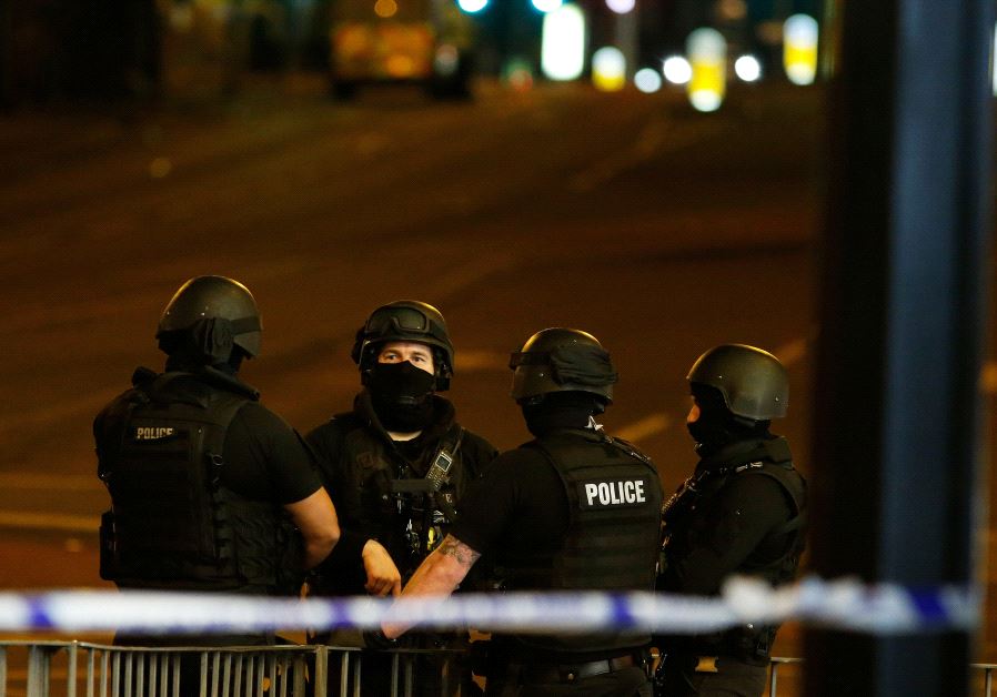 Armed police officers stand near the Manchester Arena, where US singer Ariana Grande had been performing, in Manchester, northern England, Britain May 23, 2017. 