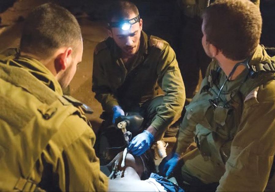 IDF SOLDIERS provide medical care to a wounded Syrian.