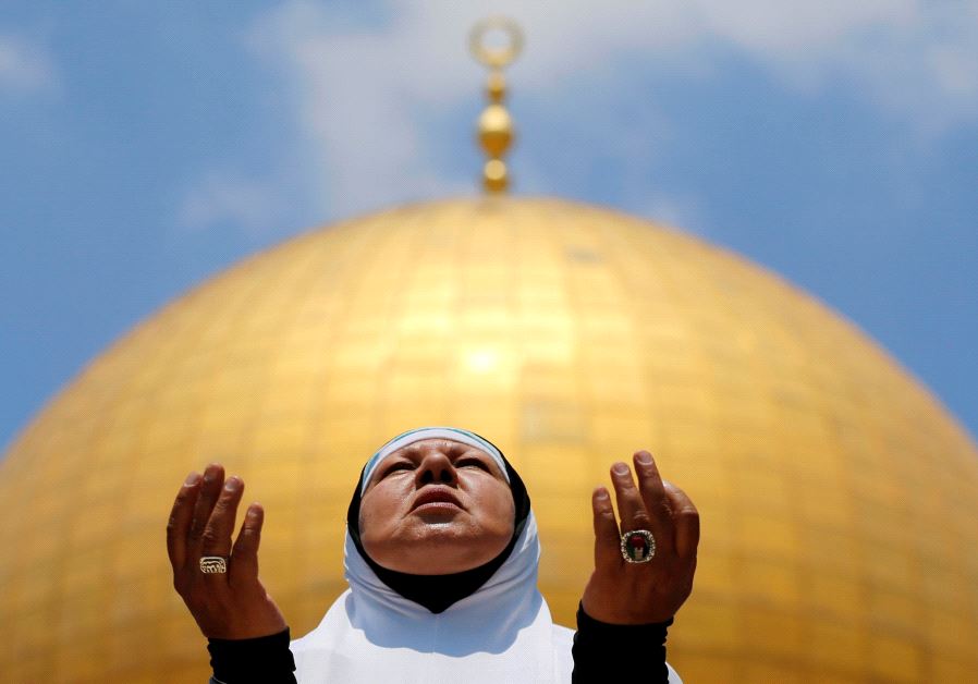 A Palestinian woman prays on the first Friday of the holy fasting month of Ramadan, at the Temple Mount in Jerusalem's Old City June 2, 2017.