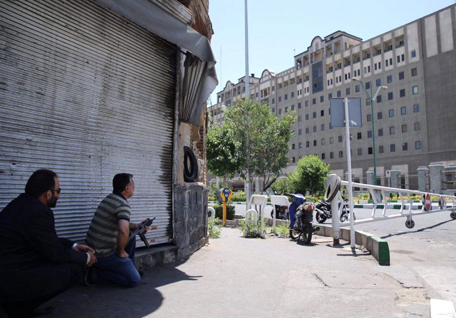 Members of Iranian forces take position during an attack on the Iranian parliament in central Tehran, Iran