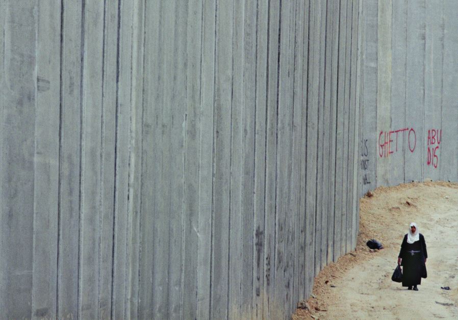 Miki Kratsman’s photo ‘Abu Dis 2003’ shows a Palestinian woman walking along the separation barrier in east Jerusalem