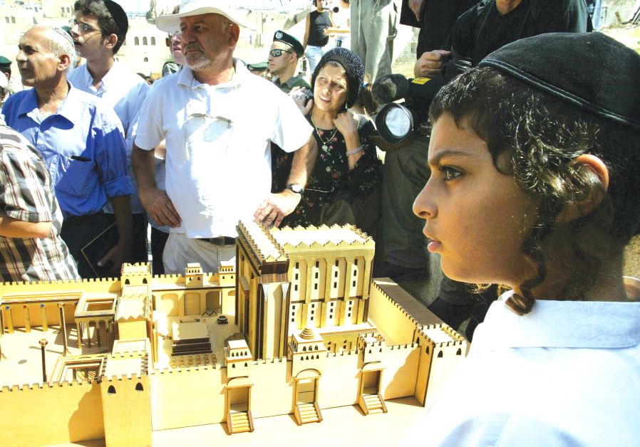 A young boy stands by a model of the Second Temple during a demonstration by Jewish ultra-right-wing protesters at the Western Wall on Tisha Be’av, 2003