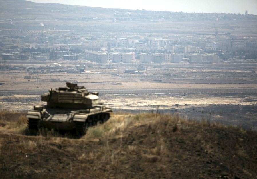 The Syrian area of Quneitra is seen in the background as an out-of-commission Israeli tank parks on a hill, near the ceasefire line between Israel and Syria, in the Golan Heights.