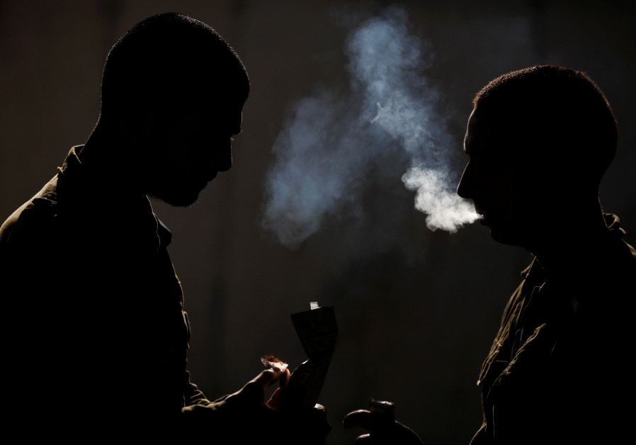 Silhouetted Israeli soldiers from the Home Front Command Unit take a smoking break during an urban warfare drill inside a mock village at Tze'elim army base in Israel's Negev Desert June 11, 2017
