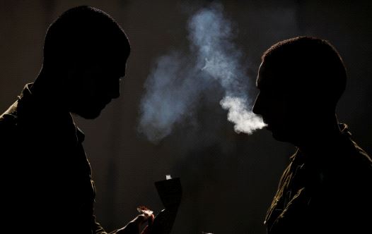 Silhouetted Israeli soldiers from the Home Front Command Unit take a smoking break during an urban warfare drill inside a mock village at Tze'elim army base in Israel's Negev Desert June 11, 2017