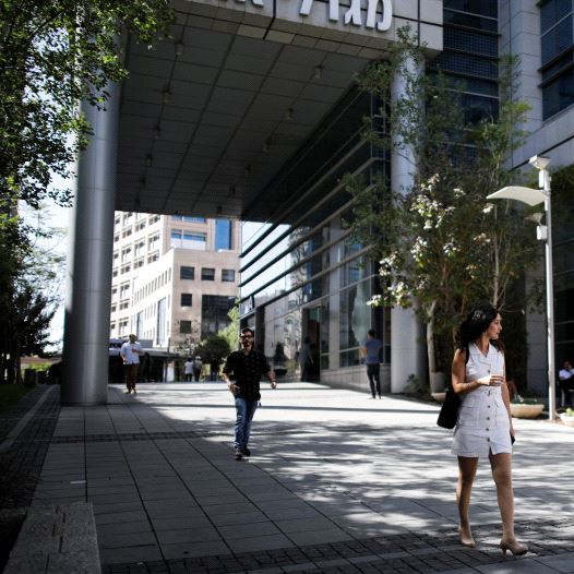 A woman walks near high-rise buildings in the hi-tech business area of Tel Aviv