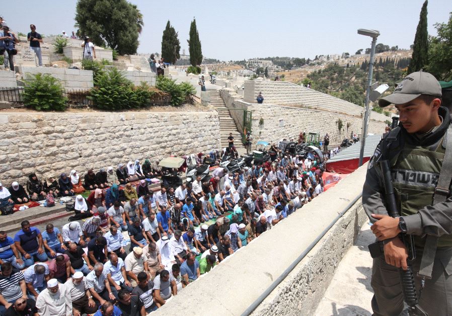 An Israeli soldier looks over a massive prayer session outside the Lions' Gate in Jerusalem, July 2017