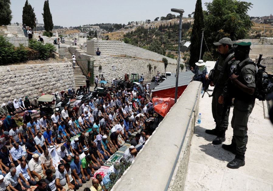 Israeli border police officers stand guard as Palestinians pray at Lions' Gate, the entrance to Jerusalem's Old City, in protest over Israel's new security measures at the Temple Mount July 20, 2017.