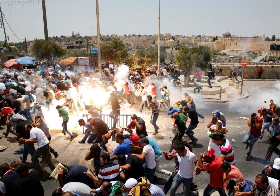 Palestinians react following tear gas that was shot by Israeli forces after Friday prayer on a street outside Jerusalem's Old city July 21, 2017.