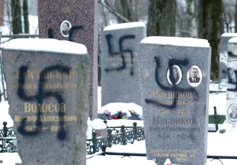 TOMBS DAUBED with Nazi swastikas are seen at a cemetery in St. Petersburg, Russia, in 2004.
