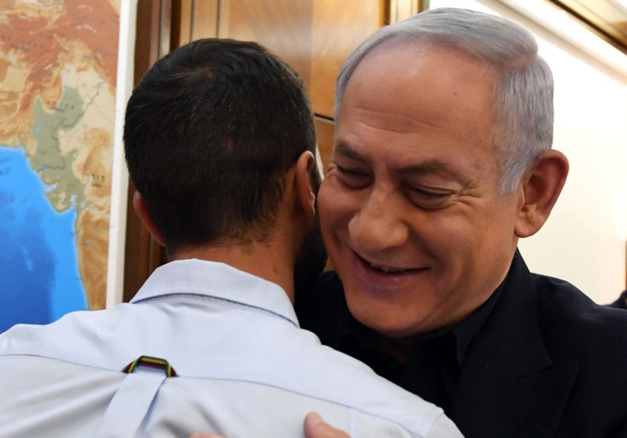 Israeli Prime Minister Benjamin Netanyahu hugs the security guard from the Israeli embassy in Amman Jordan who was stabbed by a terrorist