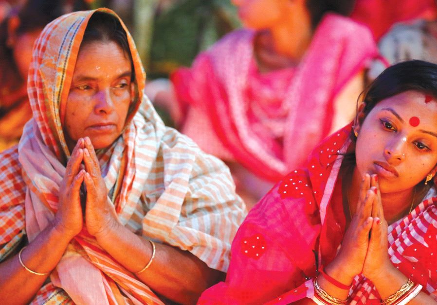 HINDU DEVOTEES sit together on the floor of a temple to observe Rakher Upabash for the last day, in Dhaka, B
