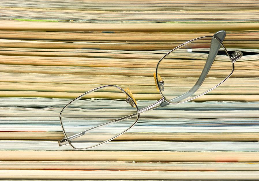 glasses on the background of the stack of magazines